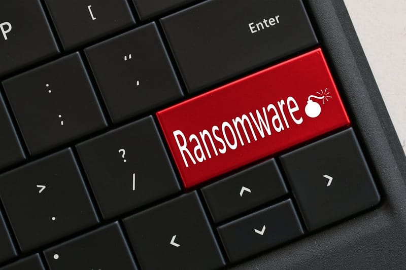 Ransomware concept - Computer Keyboard with red RANSOMWARE and lit bomb. Hacked virus cyber attack